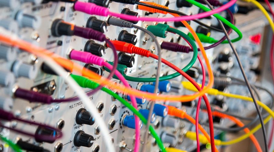 Close-up, shallow-focus photo of a switch board with colorful knobs and wires